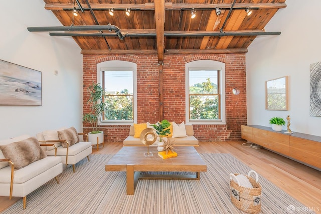 sitting room featuring brick wall, light hardwood / wood-style floors, and wooden ceiling