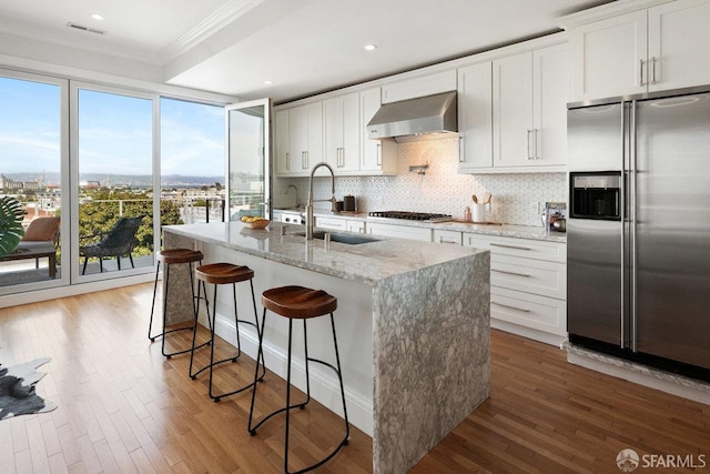 1758 Palou Ave, San Francisco, CA 94124 - kitchen with stainless steel refrigerator with ice dispenser, wall chimney range hood, ornamental molding, decorative backsplash, and a kitchen island with sink