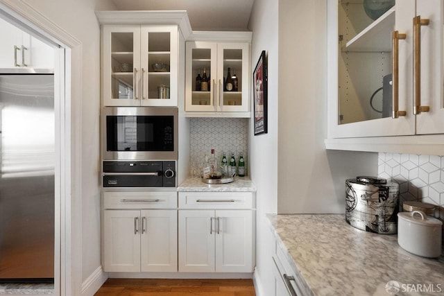 1758 Palou Ave, San Francisco, CA 94124 - bar featuring built in appliances, decorative backsplash, a warming drawer, and light wood-style flooring