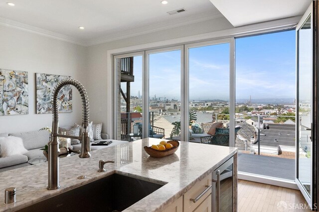 1758 Palou Ave, San Francisco, CA 94124 - kitchen with wine cooler, a sink, light stone counters, light wood-style floors, and recessed lighting