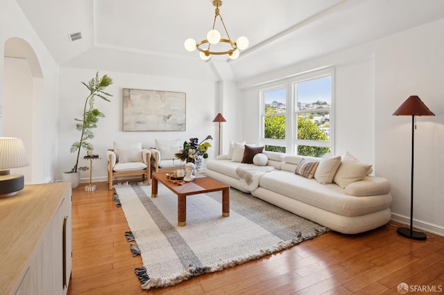 67 Rome St, San Francisco, CA 94112 - living area featuring a raised ceiling, arched walkways, light wood-style flooring, and a chandelier