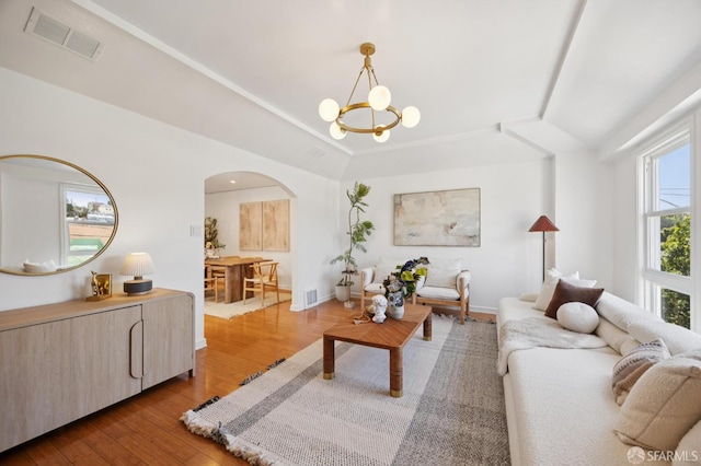 67 Rome St, San Francisco, CA 94112 - living room featuring arched walkways, wood-type flooring, a chandelier, and a raised ceiling