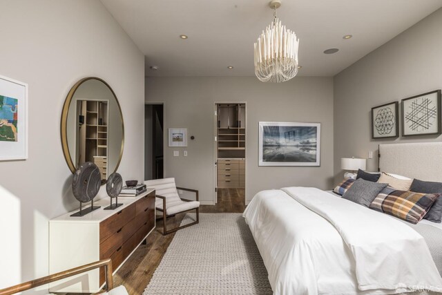 bedroom with a chandelier, a spacious closet, dark wood finished floors, and recessed lighting