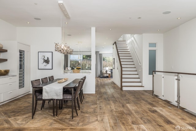 dining area with stairs, recessed lighting, an inviting chandelier, and wood finished floors