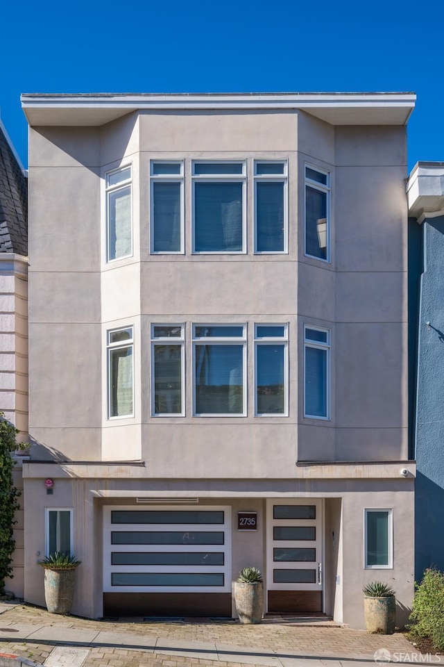 exterior space with an attached garage and stucco siding