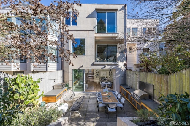 back of house with a patio area, fence, exterior kitchen, and stucco siding