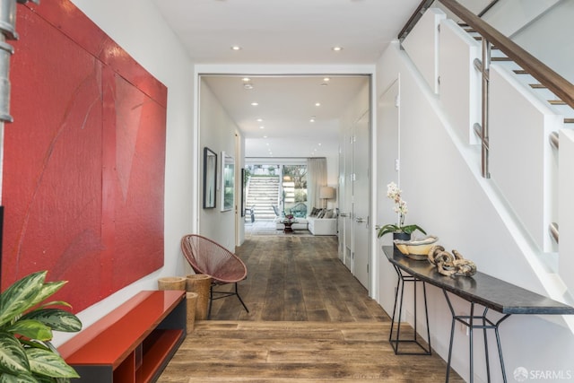 corridor featuring stairs, wood finished floors, and recessed lighting