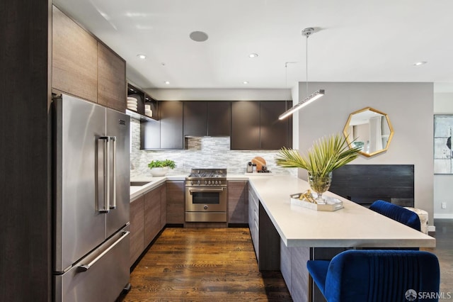 kitchen with modern cabinets, light countertops, a breakfast bar area, and high quality appliances