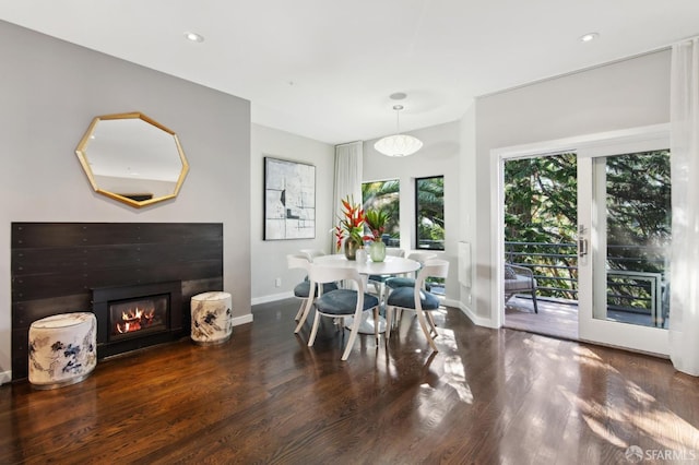 dining room featuring dark wood-style flooring, recessed lighting, a glass covered fireplace, and baseboards