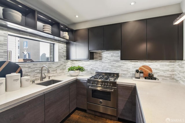 kitchen featuring tasteful backsplash, stainless steel stove, light countertops, a sink, and dark brown cabinetry