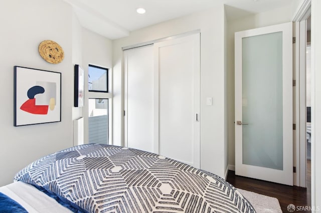 bedroom with dark wood-style flooring, a closet, and recessed lighting