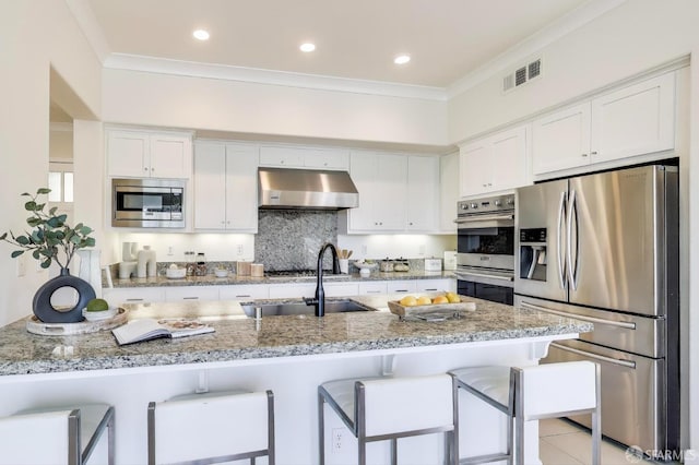 165 Summit Way, San Francisco, CA 94132 - kitchen featuring appliances with stainless steel finishes, exhaust hood, white cabinets, a kitchen bar, and a sink
