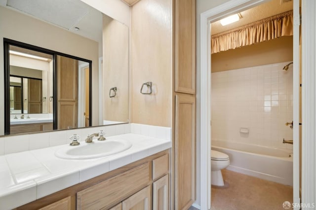 full bathroom featuring tiled shower / bath, vanity, and toilet