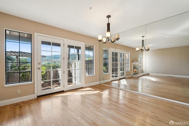 doorway featuring an inviting chandelier and light hardwood / wood-style floors