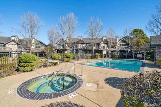 view of pool with a hot tub and a patio area