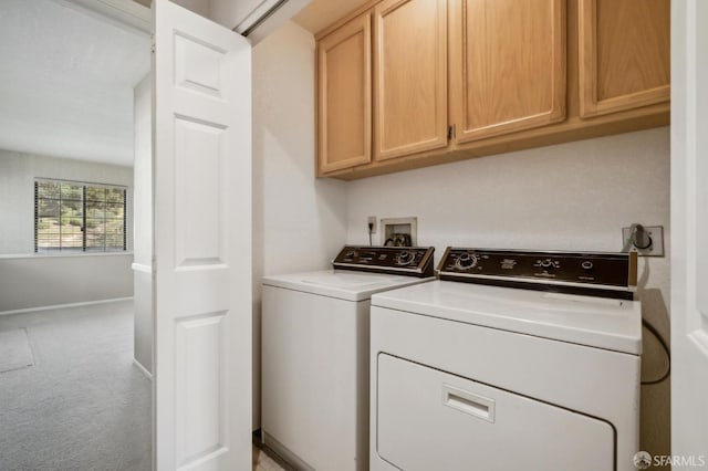 clothes washing area featuring cabinets, light colored carpet, and independent washer and dryer