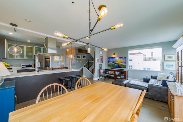 dining space with a toaster, stairs, and wood finished floors