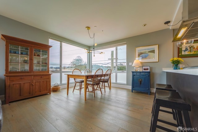 dining space with light wood finished floors and baseboards