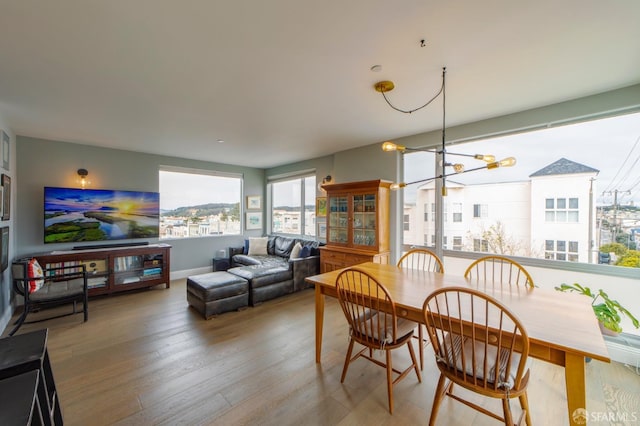 dining space with a notable chandelier and wood finished floors