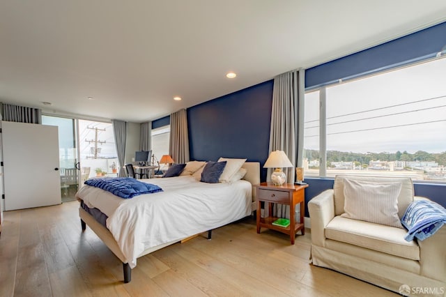 bedroom with access to exterior, recessed lighting, and wood-type flooring