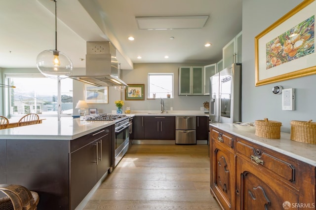 kitchen featuring stainless steel appliances, light countertops, light wood-style flooring, and a peninsula