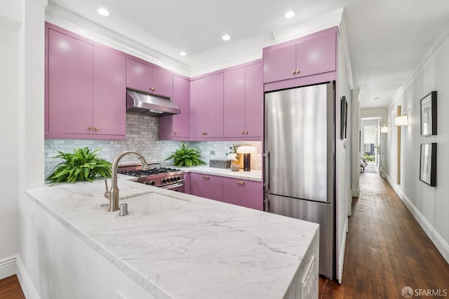1144 York St, San Francisco, CA 94110 - kitchen with stainless steel appliances, red cabinetry, under cabinet range hood, ornamental molding, and recessed lighting