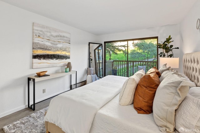 bedroom with dark hardwood / wood-style floors and access to outside