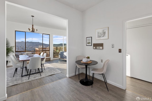 dining room featuring dark hardwood / wood-style flooring, a mountain view, and an inviting chandelier