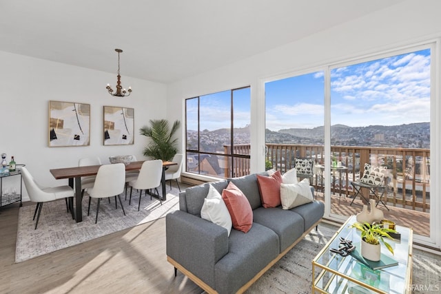 living room featuring a chandelier, a healthy amount of sunlight, a mountain view, and hardwood / wood-style floors