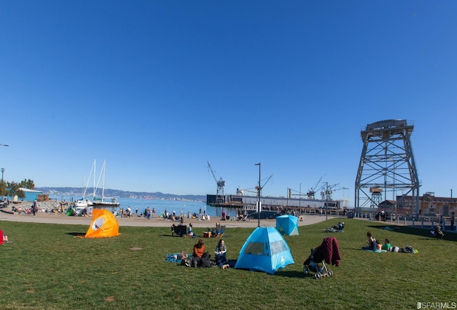 view of home's community with a water view and a lawn