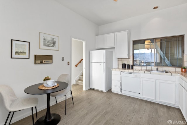 kitchen featuring tasteful backsplash, sink, white cabinets, white appliances, and light wood-type flooring