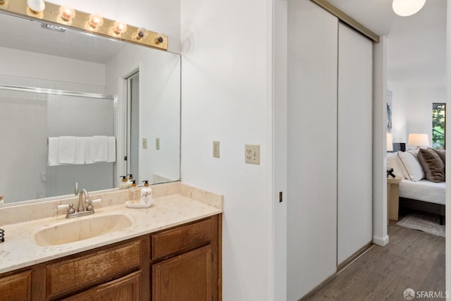 bathroom with vanity, hardwood / wood-style floors, and an enclosed shower