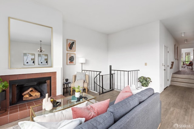 living room featuring an inviting chandelier, hardwood / wood-style floors, and a fireplace