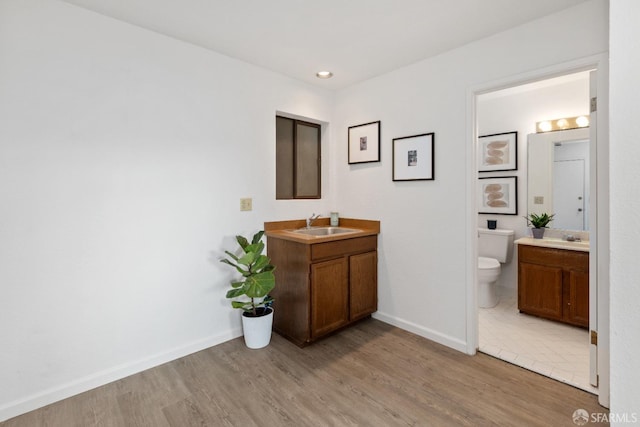 bathroom with wood-type flooring, toilet, and vanity