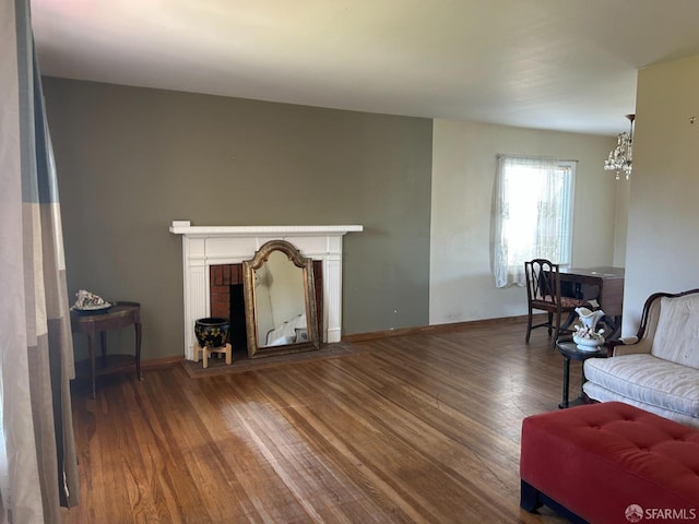 living area with a fireplace, baseboards, and wood finished floors