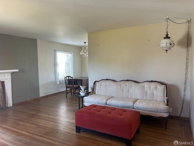 living area featuring baseboards, a chandelier, and wood finished floors