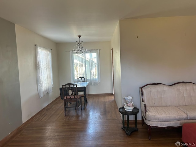 dining area featuring a chandelier, wood finished floors, and baseboards