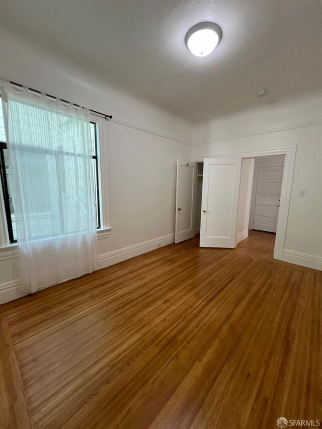 unfurnished room with hardwood / wood-style flooring