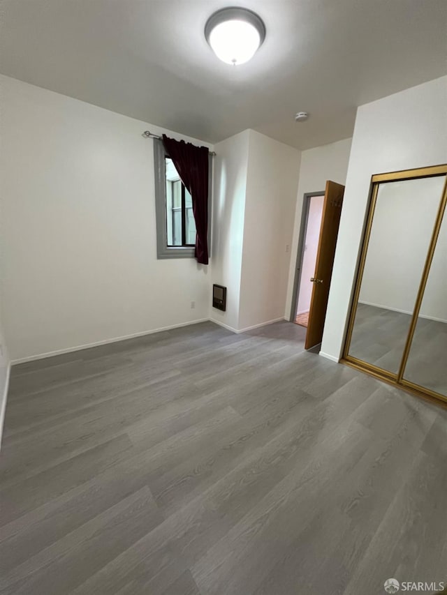 unfurnished bedroom featuring hardwood / wood-style floors and a closet