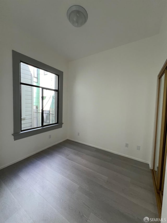 unfurnished room with dark wood-type flooring