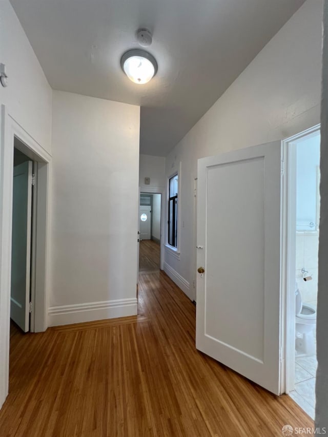 hallway with light hardwood / wood-style floors