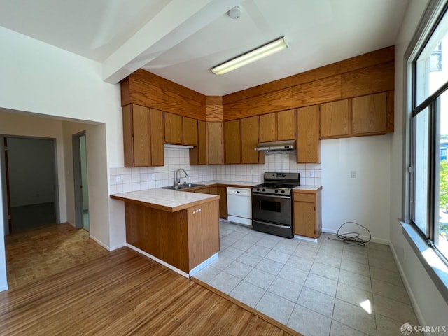 kitchen with tile counters, white dishwasher, range with gas stovetop, and a healthy amount of sunlight