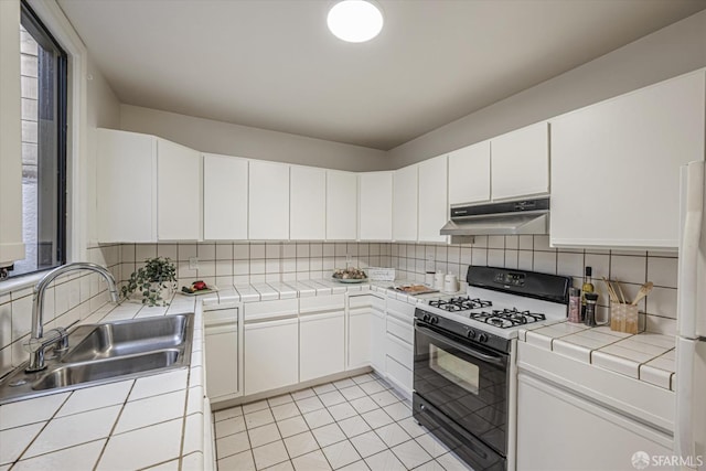 kitchen featuring tile counters, tasteful backsplash, white cabinetry, sink, and range with gas cooktop