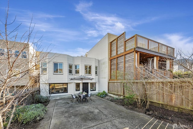 rear view of house featuring a balcony and a patio