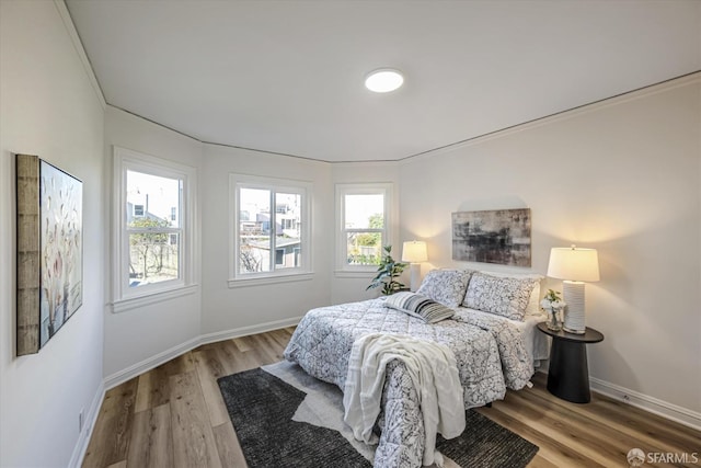 bedroom featuring wood-type flooring and crown molding