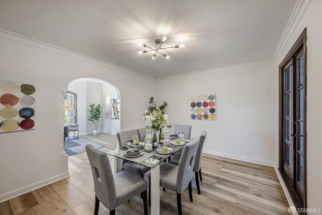 dining space with ornamental molding and light hardwood / wood-style floors