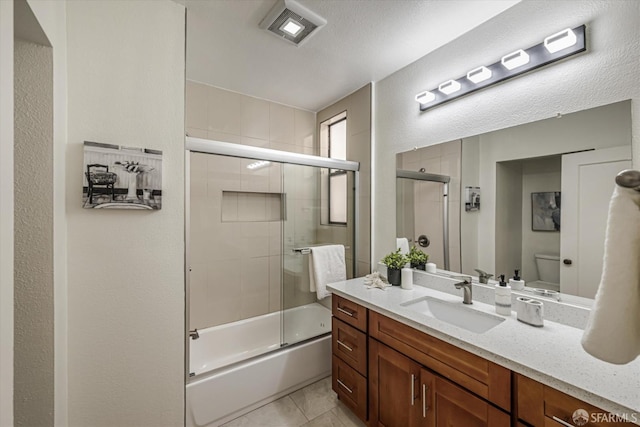 full bathroom featuring tile patterned floors, vanity, toilet, and combined bath / shower with glass door