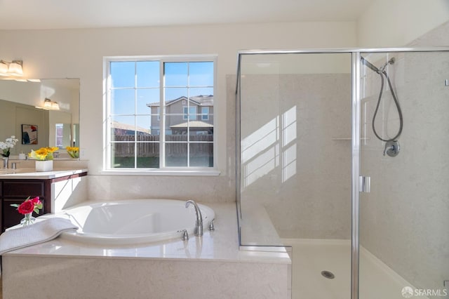 bathroom featuring vanity, plus walk in shower, and a healthy amount of sunlight