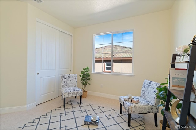 living area featuring light carpet