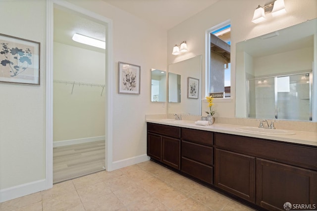 bathroom featuring tile patterned flooring, vanity, and a shower with shower door